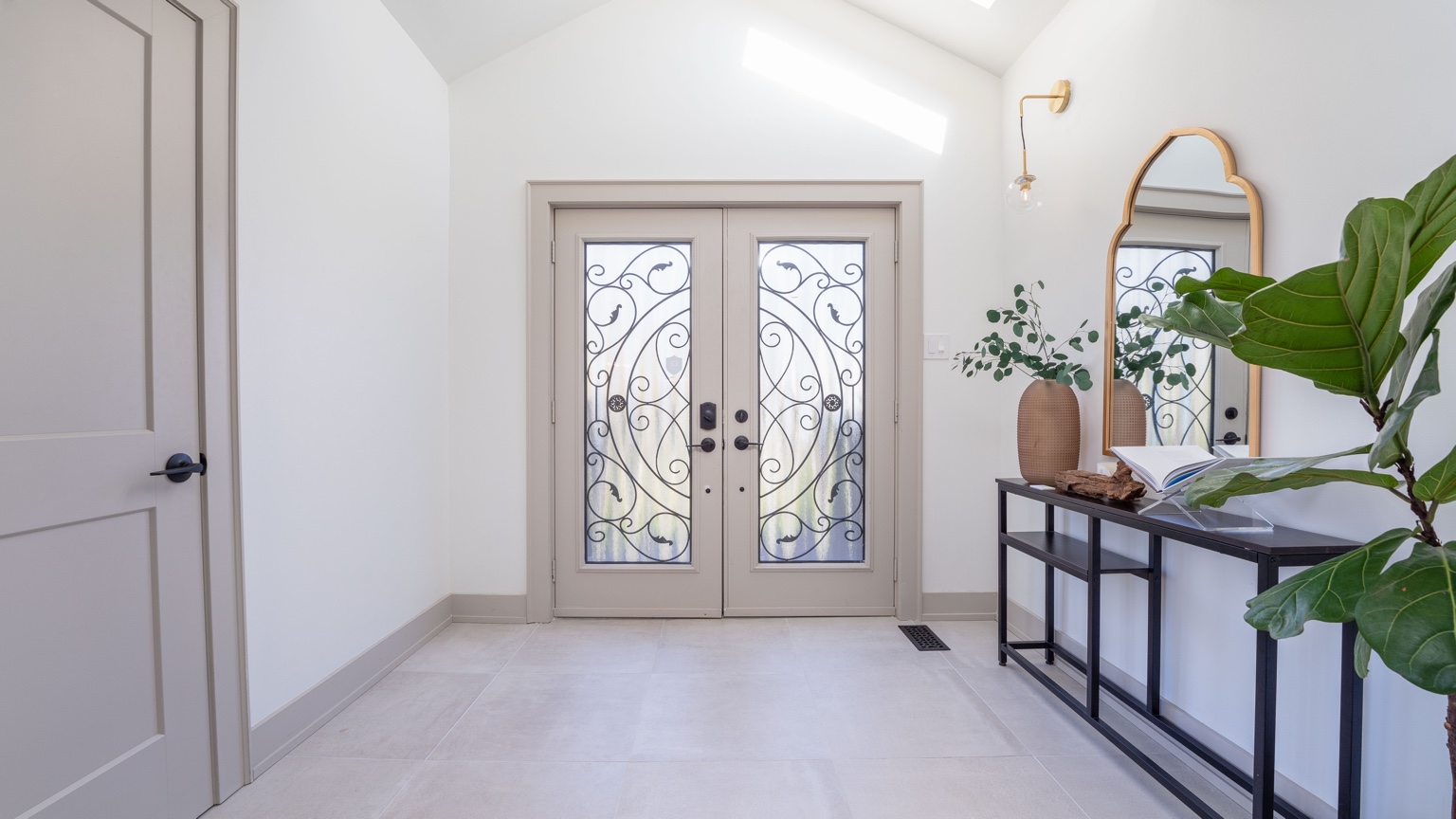 Finished home entry with double decorative doors and tile floor